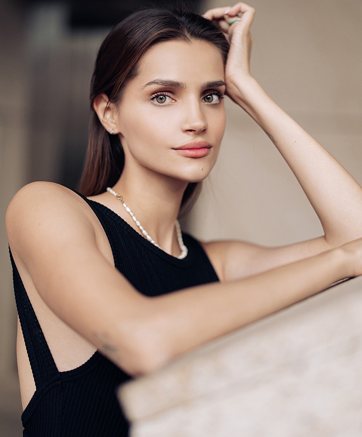 Woman in black top with natural makeup.