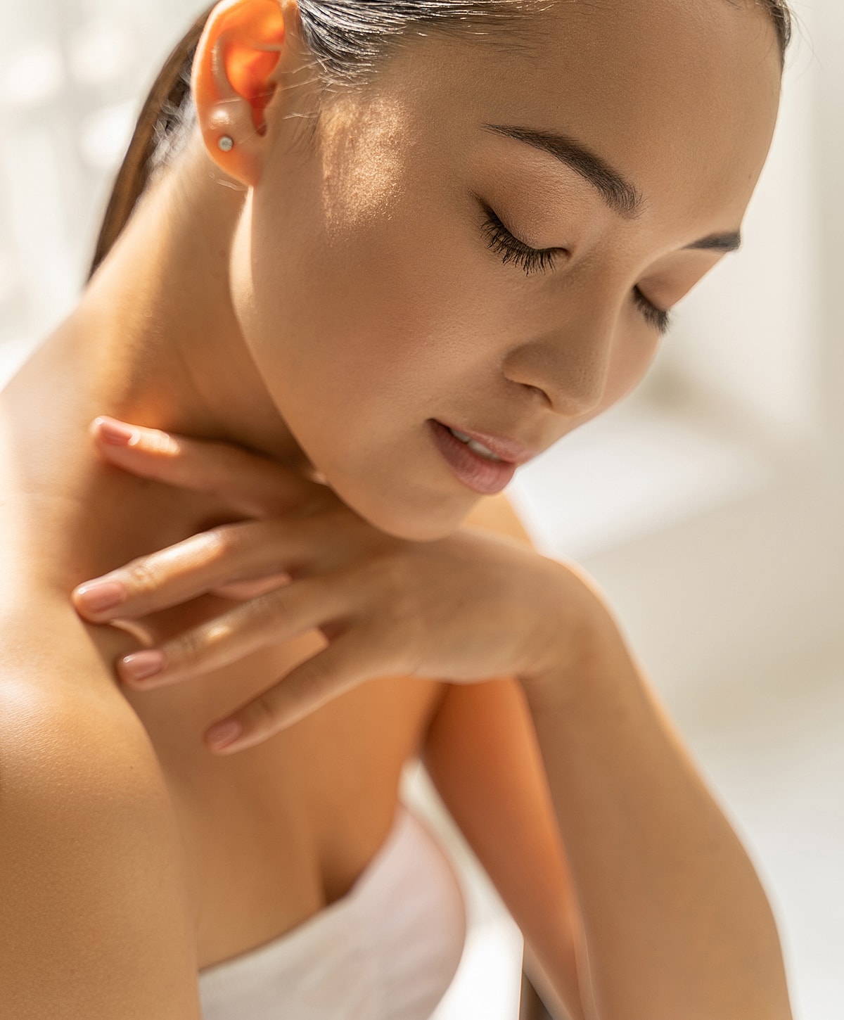 Woman with closed eyes in soft light.